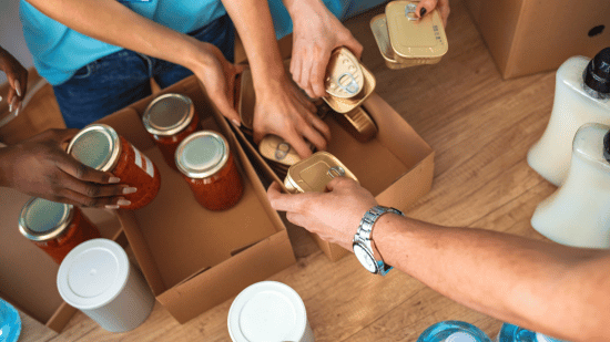 Arms placing jars of food in a box