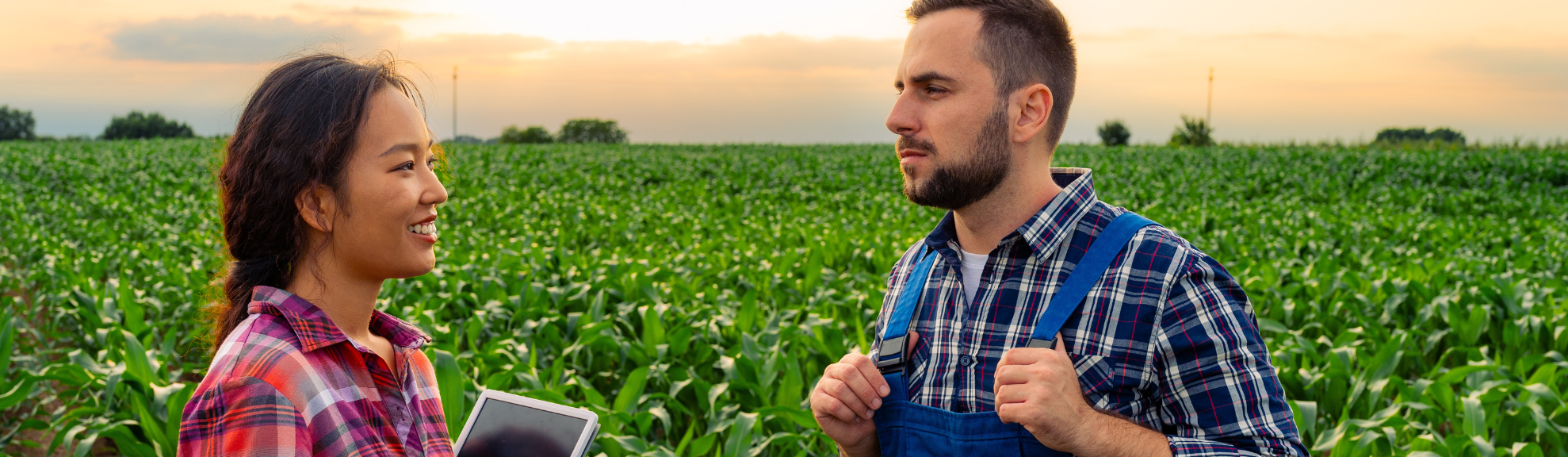 A young man and woman speaking in a field