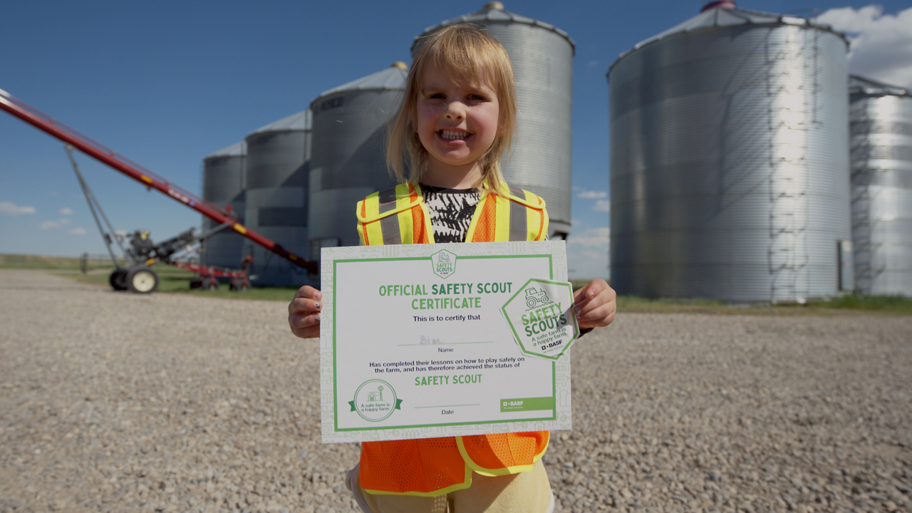 Girl holding a Safety Scout certificate
