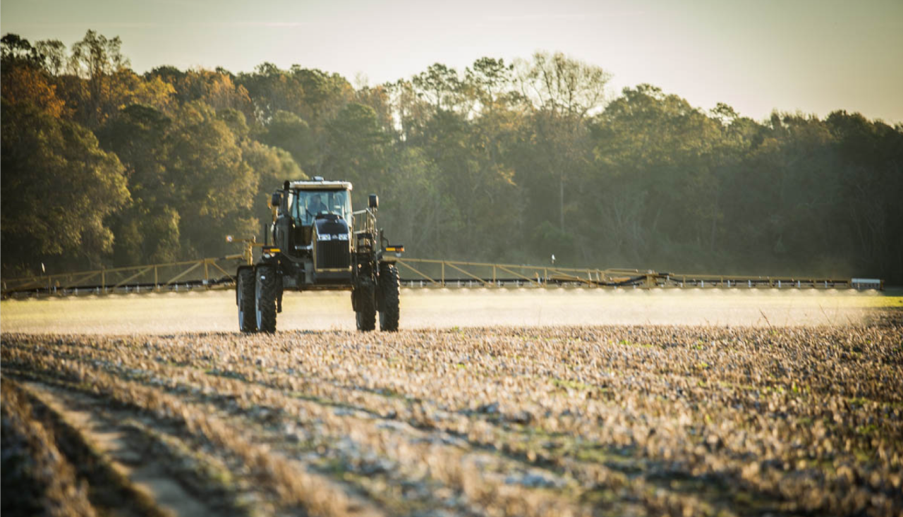 Image of tractor with sprayer, spraying a field